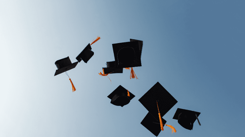 Des toques de diplômés lancées en l’air, symbolisant la célébration et la réussite.