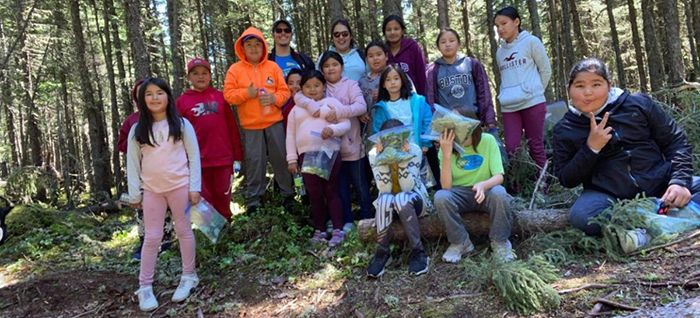 Un groupe d'enfants devant de grands pins